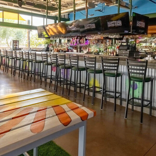 Bright, colorful area with large windows and eclectic furniture.