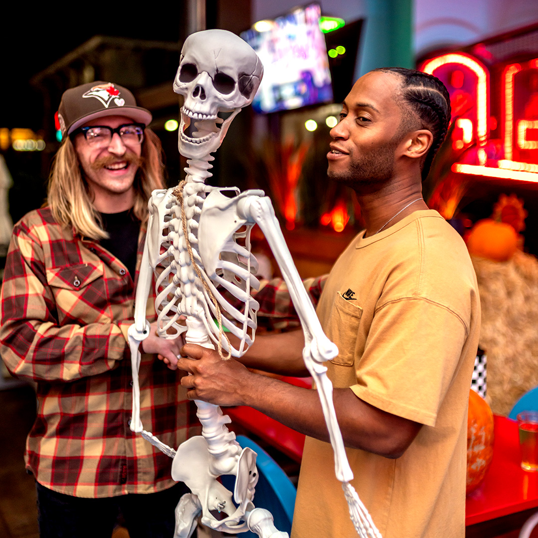 Two guys dancing with a skeleton